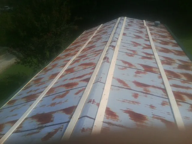 Rusted metal roof panels with new wood purlins before replacement — Storm Damage Roof Repair in Wellsville by Roofing Brothers